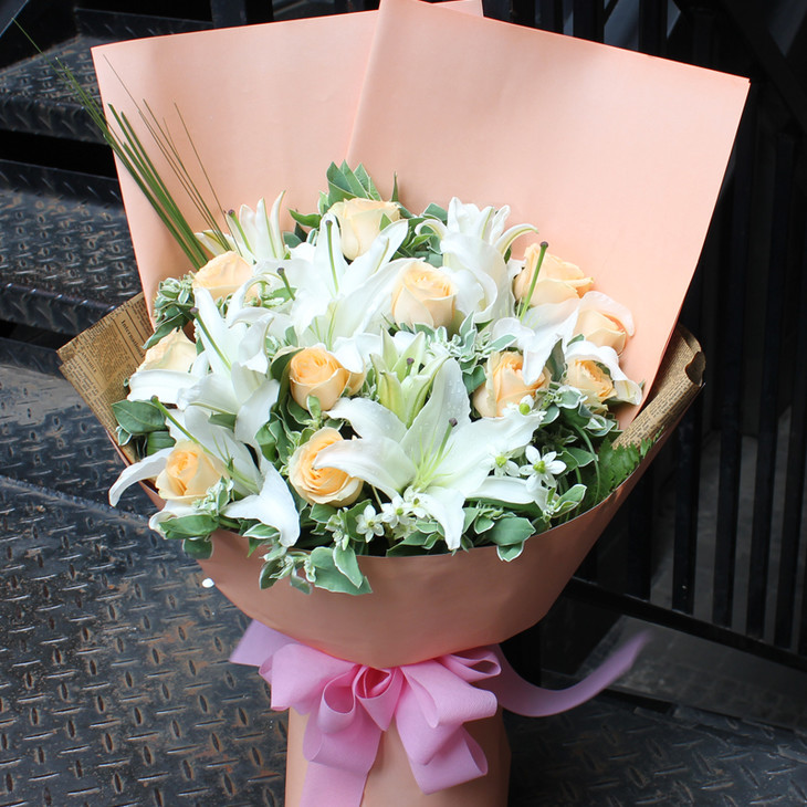 花材:香槟色的玫瑰11朵,白色2头香水百合3枝,叶材或黄英搭配